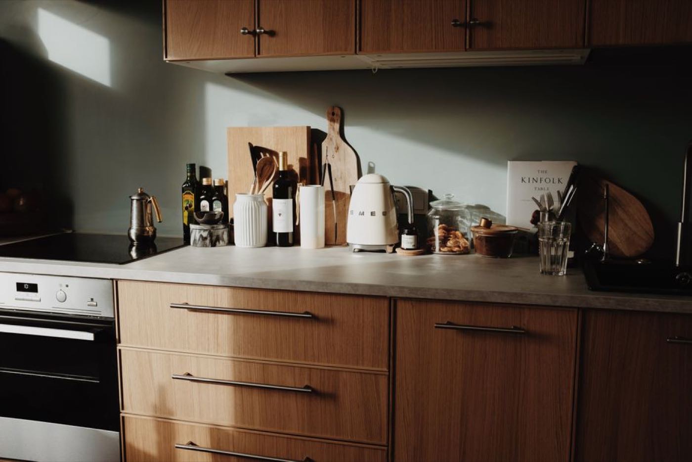 A warm wooden kitchen with a clear stretch of worktop, boards and jars along the back.